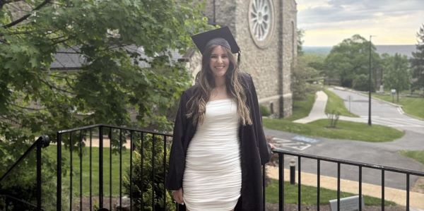 Jenna in her cap and gown behind IC chapel